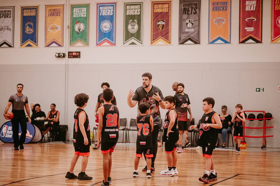 Atletas do Águias Basketball reunidos em quadra durante um jogo